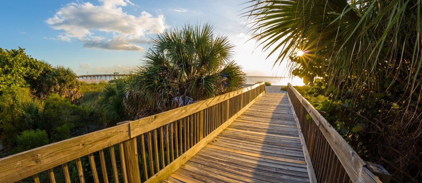 Sun shining on a boardwalk leading to the beach in Venice, Florida